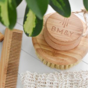 A bamboo body brush with the logo of BM&Y Skincare