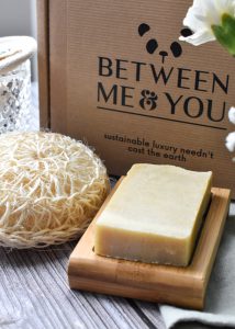 Sustainable sponge and bar of soap on a bamboo soap dish